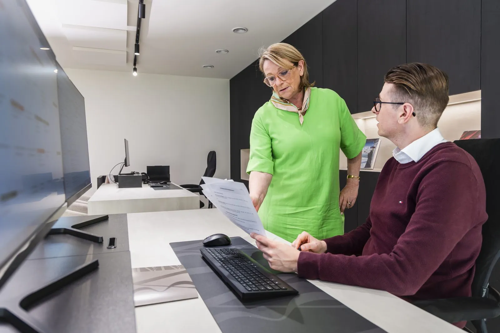 Nadia en Ruben lezen samen een polis na aan het bureau